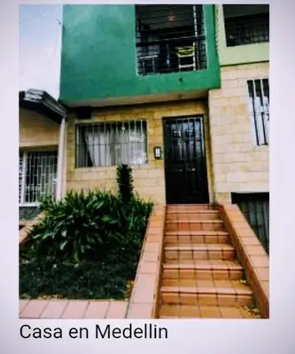 a house with a black door and stairs in front at Aldea Gloria, dúplex, familiar & Pets en Laureles in Medellín