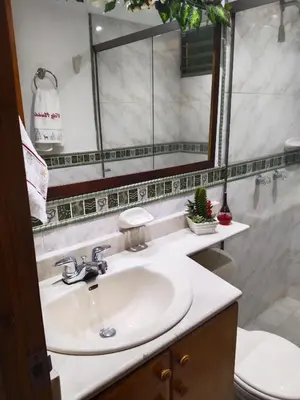 a bathroom with a sink and a toilet and a mirror at Aldea Gloria, dúplex, familiar & Pets en Laureles in Medellín