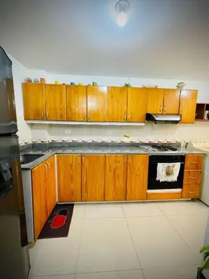 a kitchen with wooden cabinets and a stove top oven at Aldea Gloria, dúplex, familiar & Pets en Laureles in Medellín