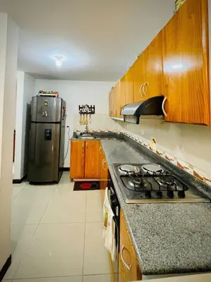 a kitchen with a stove and a refrigerator at Aldea Gloria, dúplex, familiar & Pets en Laureles in Medellín