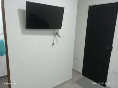 a flat screen tv on a wall next to a door at Alojamientos Jamar in Rionegro