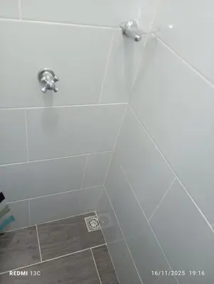 a bathroom with a shower with a white tile wall at Alojamientos Jamar in Rionegro