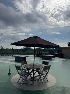 a table and two chairs under an umbrella at Hotel Rioverde Suite Cerca de Aeropuerto JMC in Rionegro