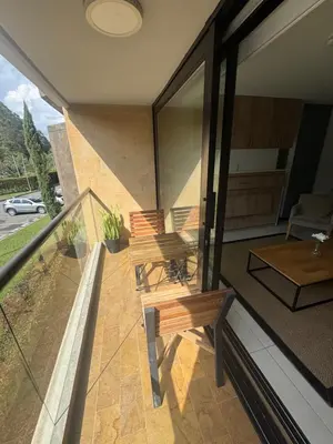 a balcony of a house with two benches and a table at Hotel Rioverde Suite Cerca de Aeropuerto JMC in Rionegro