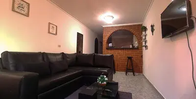 a living room with a leather couch and a television at Apartamento Rionegro, cerca de San Nicolas in Rionegro