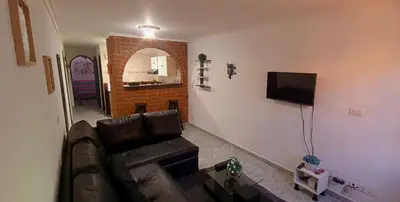 a living room with a leather couch and a television at Apartamento Rionegro, cerca de San Nicolas in Rionegro