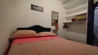 a bedroom with a bed and a sign on the wall at Apartamento Rionegro, cerca de San Nicolas in Rionegro