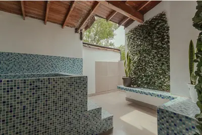a bathroom with green tiles on the wall at El lienzo Blanco en Medellin in Envigado