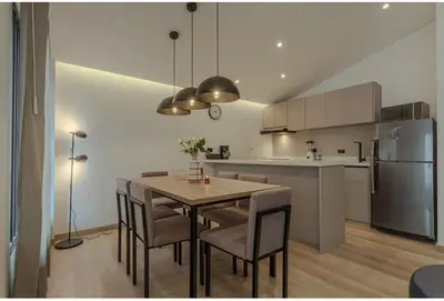 a kitchen and dining room with a table and chairs at El lienzo Blanco en Medellin in Envigado
