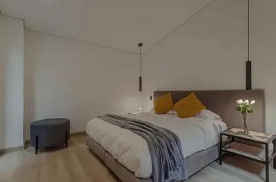 a bedroom with a large bed and a table at El lienzo Blanco en Medellin in Envigado