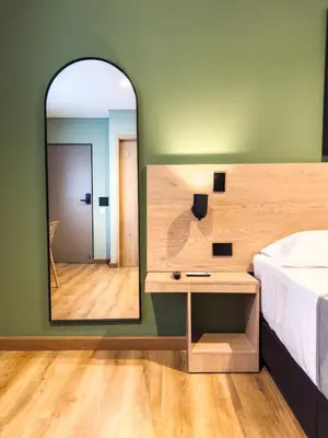 a bedroom with a mirror and a bed and a table at Habitat Ochentayuno in Medellín