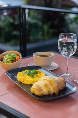 a plate of food with a glass of wine and a pastry at Habitat Ochentayuno in Medellín