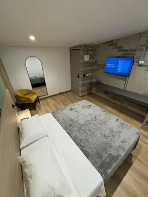 a bedroom with a bed and a flat screen tv at Habitat Ochentayuno in Medellín
