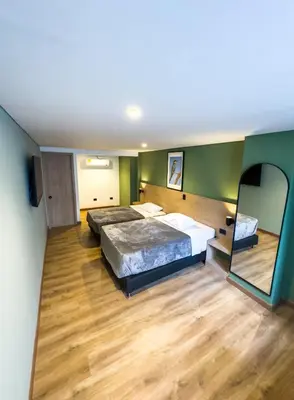 a bedroom with a large bed and a mirror at Habitat Ochentayuno in Medellín