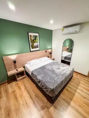 a bedroom with a large bed and a mirror at Habitat Ochentayuno in Medellín