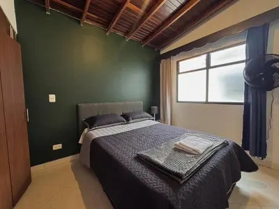 a bedroom with a bed and a green wall at Apartamento Espacioso Belen Alameda cerca a Laureles y unidad deportiva de Belen in Medellín