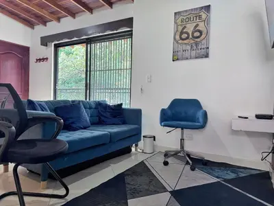 a living room with a blue couch and two chairs at Apartamento Espacioso Belen Alameda cerca a Laureles y unidad deportiva de Belen in Medellín