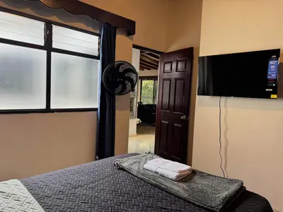 a bedroom with a bed and a flat screen tv at Apartamento Espacioso Belen Alameda cerca a Laureles y unidad deportiva de Belen in Medellín