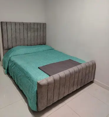 a bed with a brown headboard in a room at Confortable apartamento en el corazón de Medellín in Medellín
