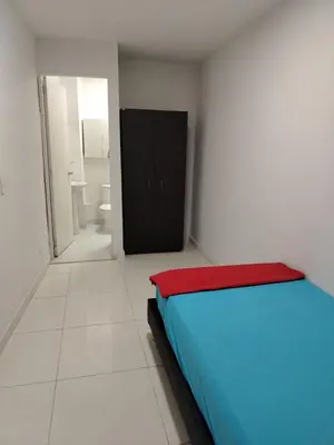 a room with a bed and a black cabinet at Confortable apartamento en el corazón de Medellín in Medellín