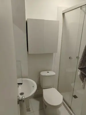 a white bathroom with a toilet and a sink at Confortable apartamento en el corazón de Medellín in Medellín