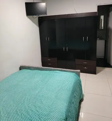 a bedroom with a bed and a black cabinet at Confortable apartamento en el corazón de Medellín in Medellín