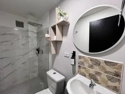 a bathroom with a toilet and a sink and a mirror at Apartamentos Virginia 34 in Medellín
