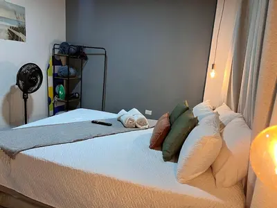 a bedroom with a bed with white sheets and pillows at Apartamentos Virginia 34 in Medellín
