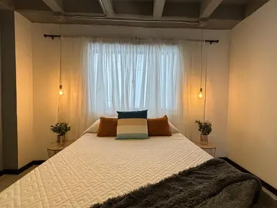 a bedroom with a large bed in front of a window at Apartamentos Virginia 34 in Medellín