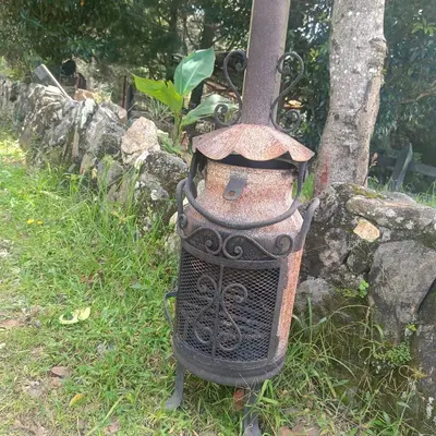 a bird feeder sitting in the grass next to a tree at Casa Finca Cerca a Medellin y Aeropuerto JMC in Guarne