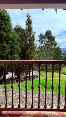 a balcony with a view of a field of grass at Casa Finca Cerca a Medellin y Aeropuerto JMC in Guarne
