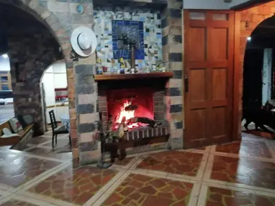 a brick fireplace in a living room with a door at Casa Finca Cerca a Medellin y Aeropuerto JMC in Guarne