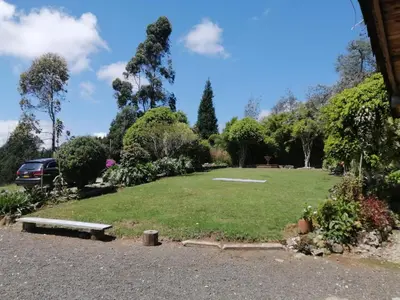 a large grassy field with a car parked in it at Casa Finca Cerca a Medellin y Aeropuerto JMC in Guarne