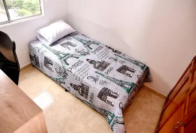 a small bedroom with a bed with a comforter at Your Mountain View Retreat in Medellín in Medellín