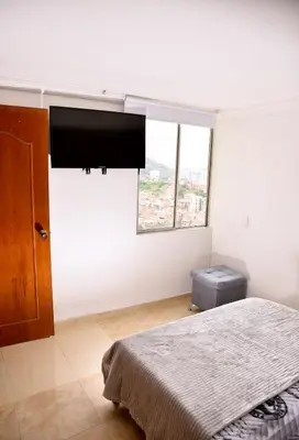 a bedroom with a bed and a large window at Your Mountain View Retreat in Medellín in Medellín