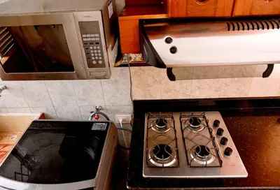 a kitchen with a stove top oven and a microwave at Your Mountain View Retreat in Medellín in Medellín