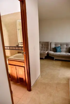 a bathroom with a sink and a couch in a room at Your Mountain View Retreat in Medellín in Medellín