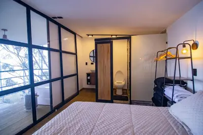 a bedroom with a bed and a bathroom with a toilet at Mist CHALETS in Santa Bárbara