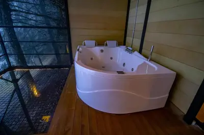 a white bath tub in a room with a window at Mist CHALETS in Santa Bárbara