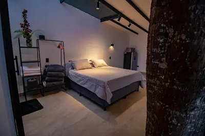 a bedroom with a bed and a chair in a room at Mist CHALETS in Santa Bárbara