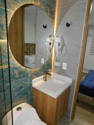 a bathroom with a sink and a mirror and a toilet at Apartasol vacacional con Piscinas en Santa Fe de Antioquia in Santa Fe de Antioquia
