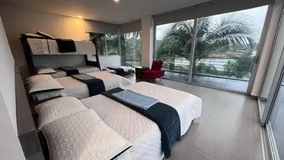 a hotel room with three beds and a large window at Villa Salomé in Guatapé in La Pradera