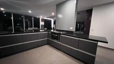 a large kitchen with black cabinets and a sink at Villa Salomé in Guatapé in La Pradera