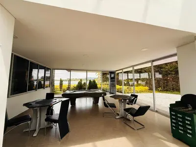 a dining room with tables and chairs and windows at Villa Salomé in Guatapé in La Pradera