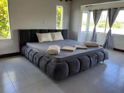 a large bed in a room with two pillows on it at Finca Vista Hermosa in La Pradera