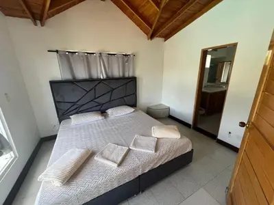 a bedroom with a large bed with white sheets and pillows at Finca Vista Hermosa in La Pradera