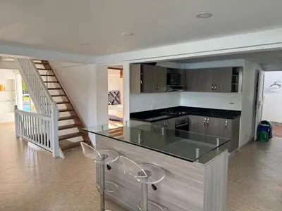 a kitchen with a glass counter and a staircase at Finca Vista Hermosa in La Pradera