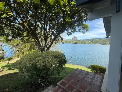 a view of a lake with a tree and a house at Finca Vista Hermosa in La Pradera