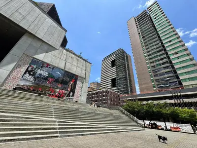 a dog walking in front of some stairs in a city at Art, design and urban life in Medellín loft in Medellín