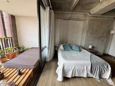 a bedroom with a bed and a mirror at Art, design and urban life in Medellín loft in Medellín